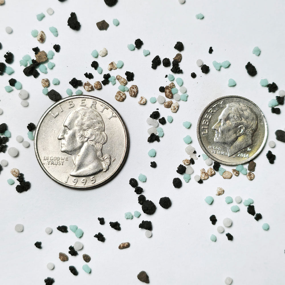 Curb appeal premium mini prills next to a quarter and a dime to show the scale of the 150 SGN granules
